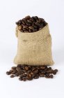 Granos de café en saco pequeño - foto de stock