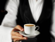 Cameriere che serve espresso in tazza — Foto stock