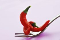 Two red chillies on fork — Stock Photo