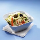 Mediterranean Cole Slaw in blue dish over towel on blue background — Stock Photo
