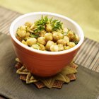 Curry Chickpeas with Parsley in orange pot over towel — Stock Photo