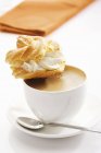 Profiterole on cup of coffee — Stock Photo