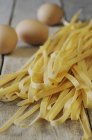 Tagliatelle and eggs on surface — Stock Photo