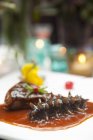 Primo piano vista del cetriolo di mare con salsa sul piatto — Foto stock
