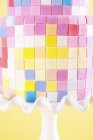 Vista de primer plano de la torta fondant con coloridos cuadrados dulces - foto de stock