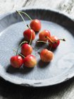 Cerejas frescas em prato de pedra — Fotografia de Stock
