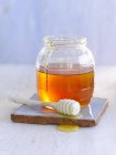 Jar of honey with dipper — Stock Photo