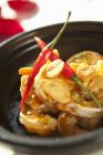 Spicy shrimp fried garlic on black plate — Stock Photo
