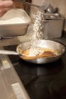 Chef versant du riz sur la casserole — Photo de stock