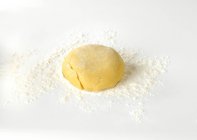 Closeup view of shortcrust pastry dough on floured white surface — Stock Photo