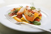 Closeup view of fruity scallop salad and fork on white plate — Stock Photo