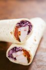 Turkey and red cabbage wraps on wooden surface — Stock Photo