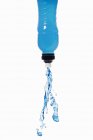 Vista de perto da bebida de energia azul esguichando para fora da garrafa — Fotografia de Stock
