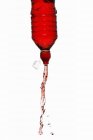 Vue rapprochée de boisson énergisante rouge éjacule hors de la bouteille — Photo de stock