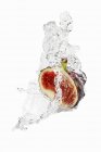 Half fig with splashing vodka — Stock Photo