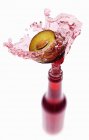 Jus de prune éclaboussant de bouteille — Photo de stock