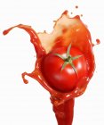 Tomato on ketchup splash — Stock Photo