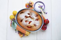Top view of plum Clafoutis with flowers and icing — Stock Photo
