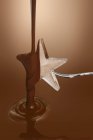 Melted chocolate over ice star — Stock Photo