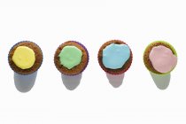 Vier Cupcakes mit buntem Zuckerguss — Stockfoto