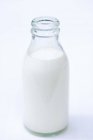 Closeup view of opened bottle of cream on white surface — Stock Photo