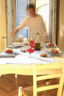 Vue de mouvement de la femme posant table à manger rustique — Photo de stock