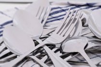 Primo piano vista di cucchiai e forchette in mucchio su strofinaccio — Foto stock
