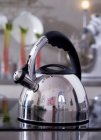 Closeup view of one metal kettle on glass cooker — Stock Photo