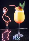 Vue rapprochée du cocktail devant la lumière néon flamant rose — Photo de stock