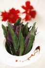 Nahaufnahme von Salatblättern in Schüssel mit Sauce — Stockfoto