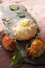 Primo piano vista di granchi di basilico alla griglia con pasta, foglie e petali su tavola scisto — Foto stock