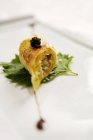 Closeup view of duck roll with black caviar on leaf — Stock Photo