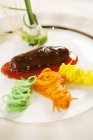 Primer plano vista de pepino de mar en salsa con fideos vegetales en plato blanco - foto de stock