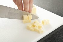 Рука різання сиру чеддер — стокове фото