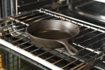 Вид крупным планом чугунной сковороды на стойку духовки — стоковое фото