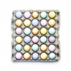 Vista superior de huevos de colores en una caja de cartón - foto de stock