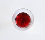 Verre de vin rouge sur la surface blanche — Photo de stock