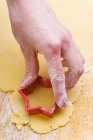 Nahaufnahme von Hand beim Ausschneiden eines Keks mit einem sternförmigen Ausstecher — Stockfoto