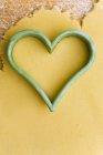 Closeup top view of heart-shaped cutter on biscuit dough — Stock Photo