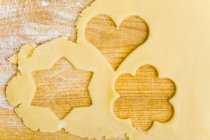 Primer plano vista superior de la masa de galletas con las formas de las galletas cortadas - foto de stock