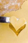 Heart-shaped biscuit on knife — Stock Photo