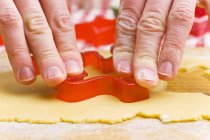 Nahaufnahme von Händen, die Keks mit Ausstecher ausschneiden — Stockfoto