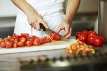 Chef cortando tomates — Fotografia de Stock
