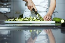 Abgeschnittene Ansicht von Koch, der Zucchini hackt — Stockfoto