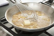 Closeup view of whisking butter in Piccata sauce in a skillet — Stock Photo