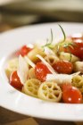 Wagon wheel pasta with tomatoes — Stock Photo