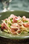 Pasta with peas and prosciutto ham — Stock Photo