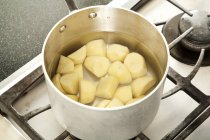 Очищенный и нарезанный картофель в кастрюле с водой для кипения — стоковое фото