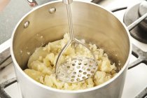 Затирання картоплю в каструлю — стокове фото