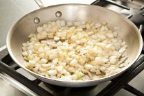 Sauteing лук в сковороде — стоковое фото